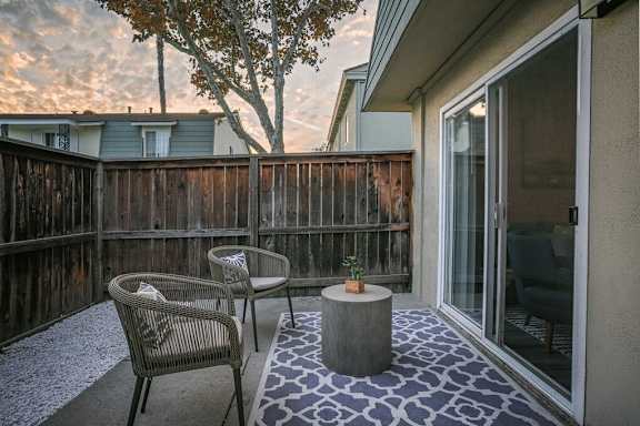 A patio with a table and chairs and a tree in the background at Nola 624 Apartments, West Covina