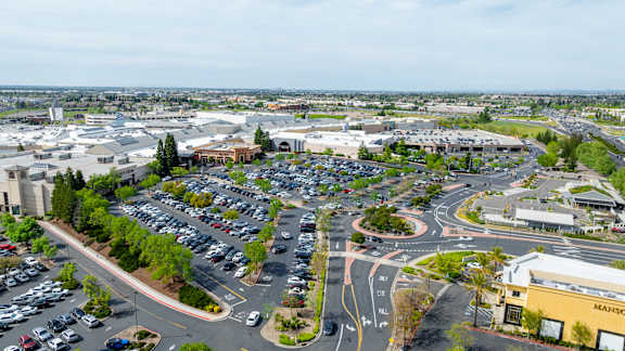 A parking lot with a few cars and a building with a sign that says "MAINSTA".