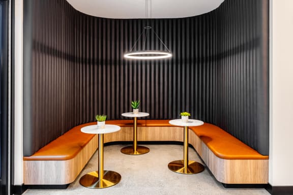 a dining room with wooden benches and tables and a lamp