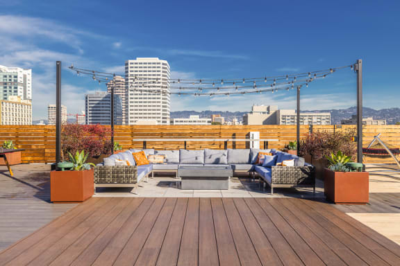 a roof deck with furniture and a city in the background