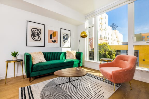 a living room with a green couch and a large window