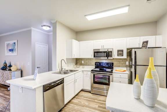 A modern kitchen with white appliances and cabinets at Avalon at Seven Hills Apartments, Henderson, Nevada