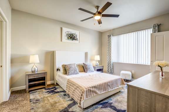 A bedroom with a bed, nightstand, and a ceiling fan at Avalon at Seven Hills Apartments, Henderson, 91790
