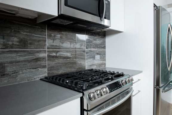 A modern kitchen with a stove and a microwave above it.