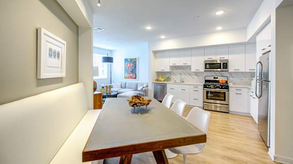 A modern kitchen with a dining table and chairs. at Baker Block, Costa Mesa, CA