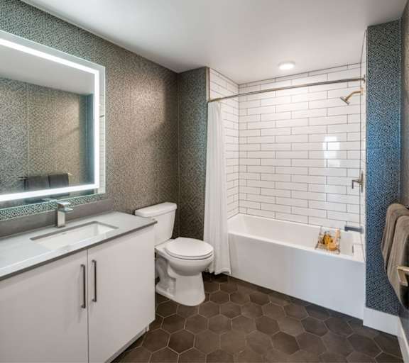 A white toilet sits next to a white sink in a bathroom.