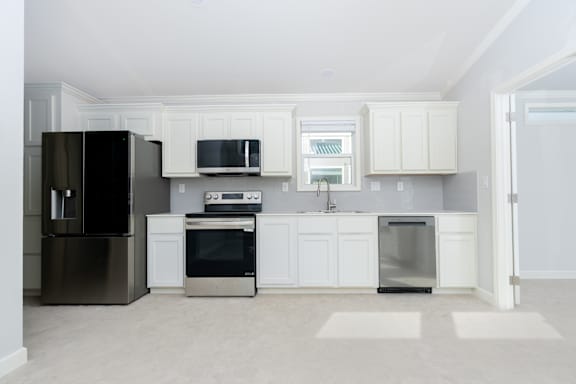 A kitchen with white cabinets and appliances.