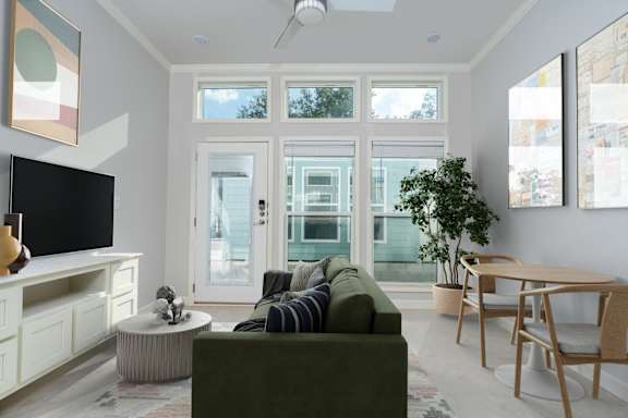 A living room with a green couch and a television.