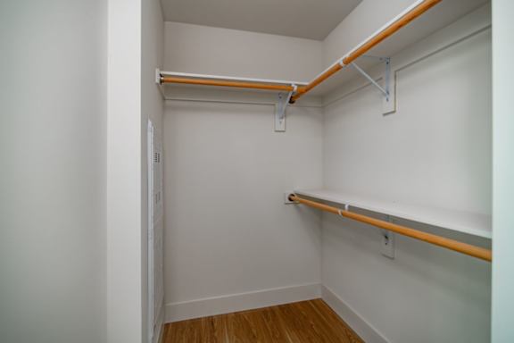 A white room with a shelf and a door.