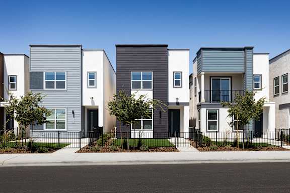 A row of modern houses with different shades of grey and white.