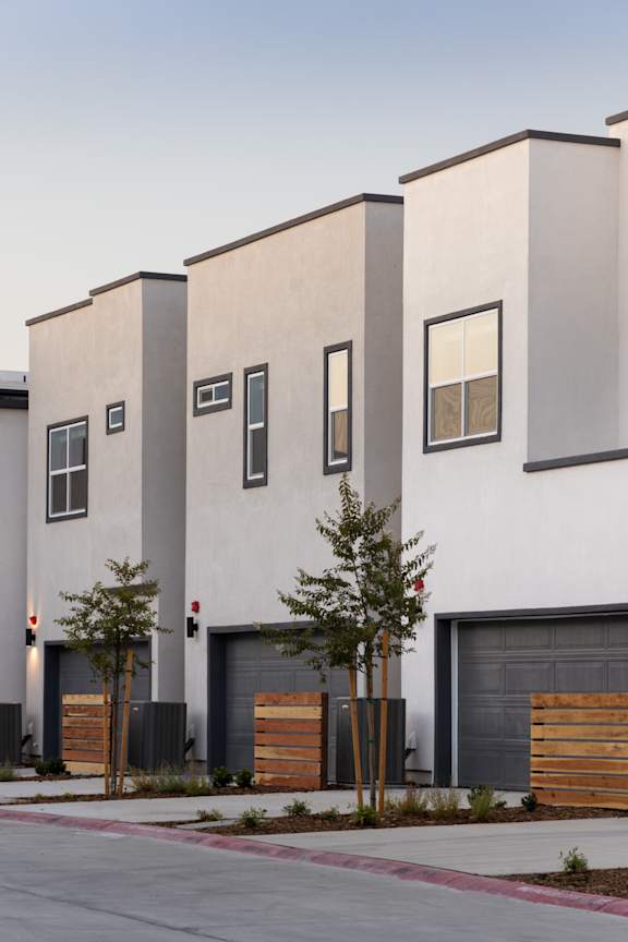 A modern building with a white facade and grey garage doors.