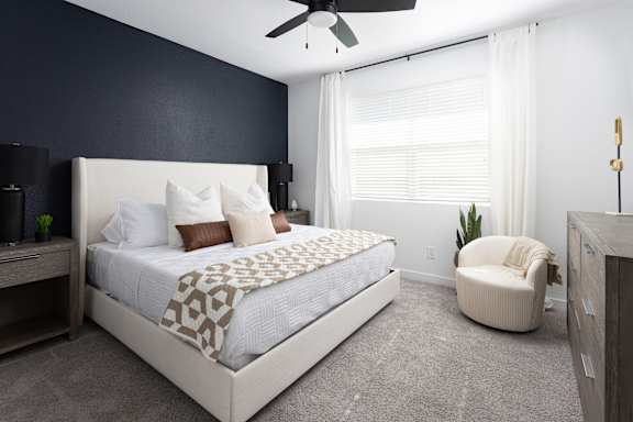 A bedroom with a large bed and a ceiling fan.