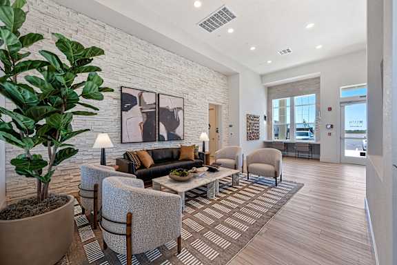 Lobby lounge with textured brick wall and artwork at Estia Roseville Apartments, Roseville, CA 95747