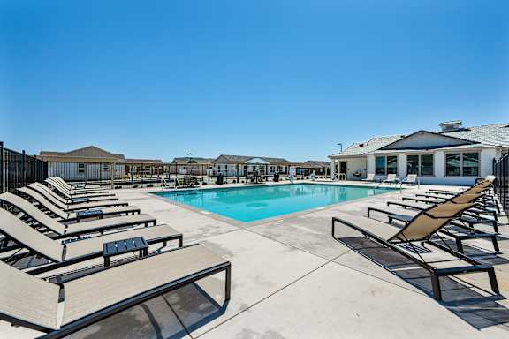 Pool deck with lounge chairs and resort style amenities at Estia Roseville Apartments, Roseville, CA