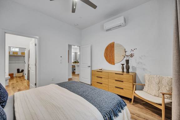 A bedroom with a bed, dresser, and mirror.