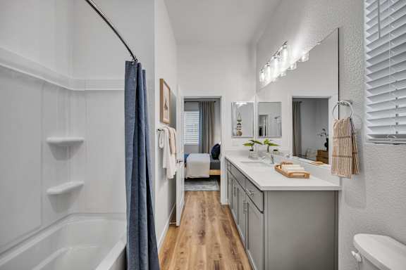 A bathroom with a white tub and sink.
