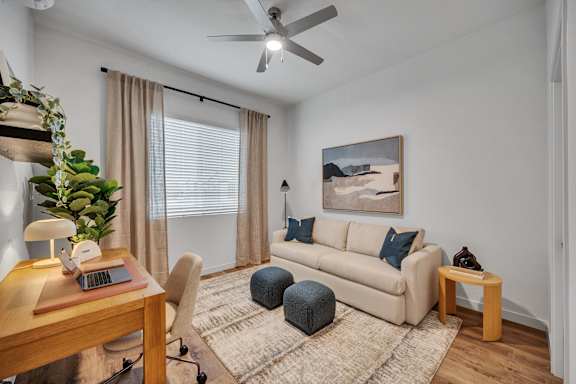 A living room with a couch, a table, and a plant.