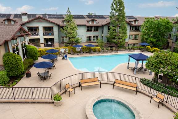 A pool area with a hot tub and loungers at 55+ FountainGlen  Jacaranda, California, 92833