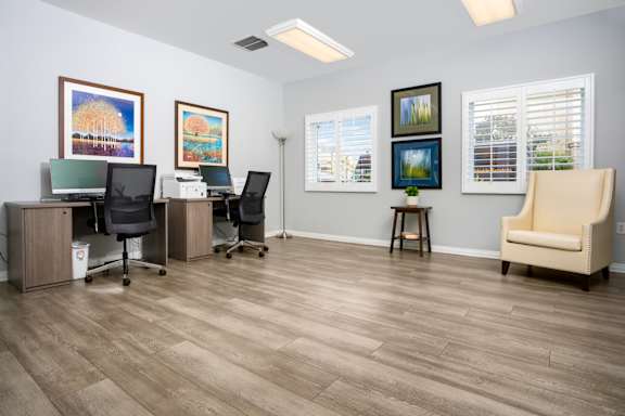 A room with a wooden floor and a chair at 55+ FountainGlen Seacliff, Huntington Beach, CA, 92648