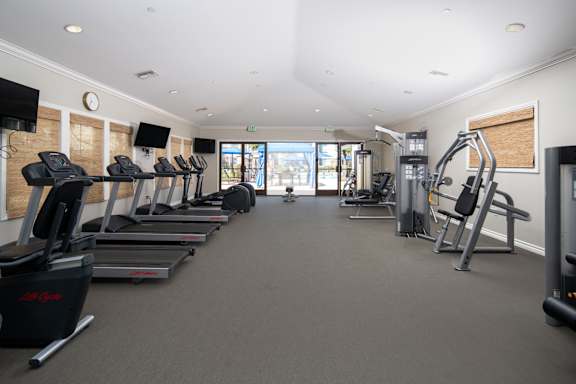 A gym with treadmills, elliptical machines, and other exercise equipment. at 55+ FountainGlen Grand Isle, Murrieta