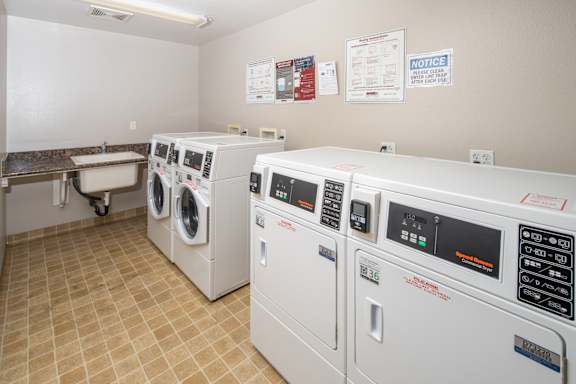 A row of washing machines in a laundromat. at 55+ FountainGlen Grand Isle, Murrieta