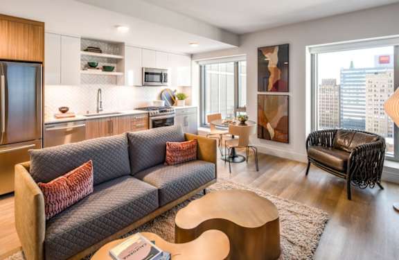 A modern living room with a grey sofa and wooden furniture.