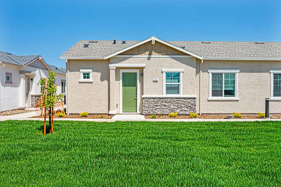 A house with a green lawn in front.
