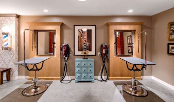 A room with a blue dresser and two bar stools.