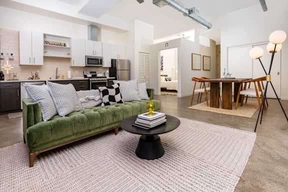 a living room with a green couch and a table at Imperial Hardware Lofts, Riverside