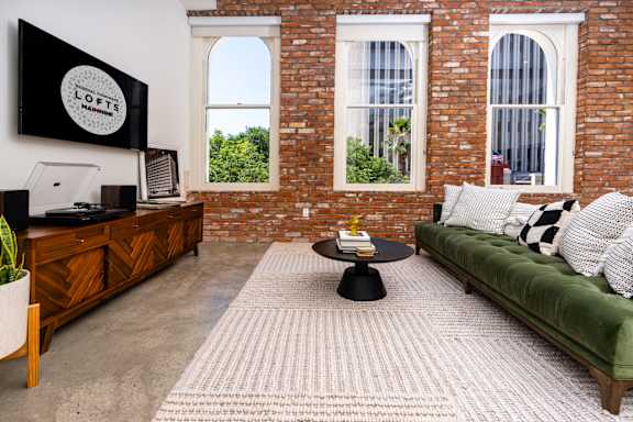 a living room with a green couch and a brick wall at Imperial Hardware Lofts, California