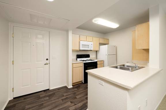A kitchen with a white counter top and wooden cabinets at 55+ FountainGlen Stevenson Ranch, Stevenson Ranch, CA