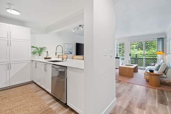 A modern kitchen with white cabinets and a stainless steel dishwasher. at Lakemont Orchard Apartments, Issaquah , WA, 98027