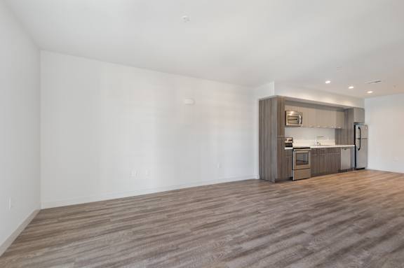 A kitchen area with a wooden floor and a white wall at Wilshire Valencia Apartment, Los Angeles, CA