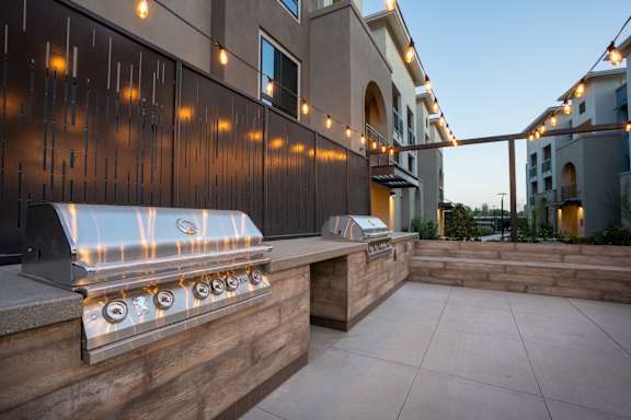 A Barbecue Grill Is On a Patio With Lights Strung Above It at North Grove, Riverside, CA, 92501