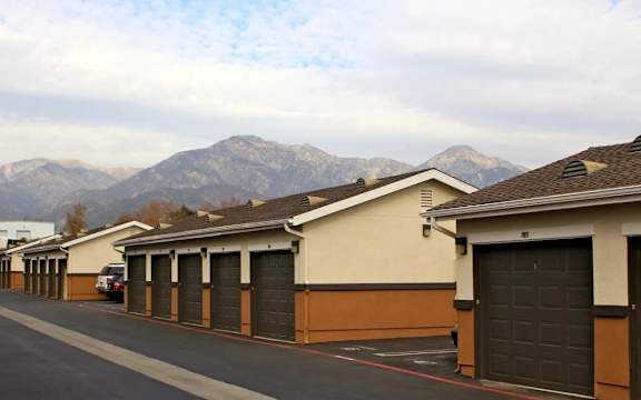 A row of garages with a mountain in the background.