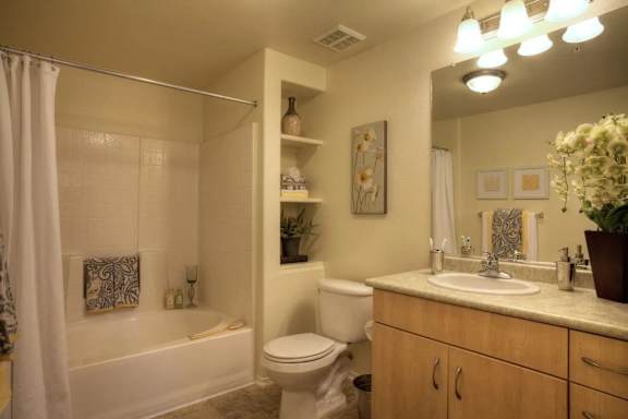A bathroom with a white tub, toilet, and sink.