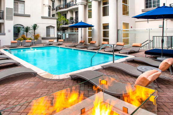Resort inspired pool with lounge seating and a firepit at The Preston Miracle Mile Apartments, Los Angeles, CA, California