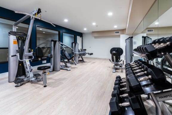 Fitness center with gym equipment and free weights at The Preston Miracle Mile Apartments, Los Angeles, CA, California