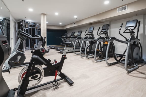 Fitness center with ellipticals and treadmills at The Preston Miracle Mile Apartments, Los Angeles