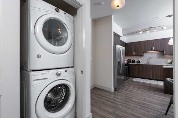 A white front loading washing machine is in a laundry room.