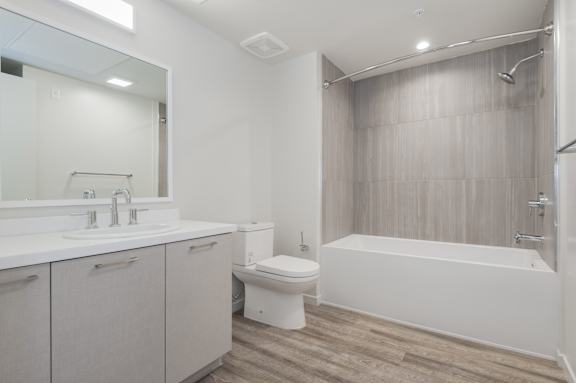 A white bathroom with a toilet, sink, and bathtub at Wilshire Valencia Apartment, California, 90017