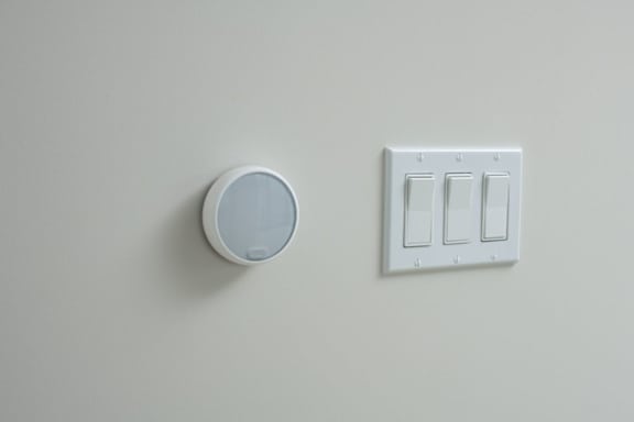 A white light switch plate and a white light switch on a white wall.
