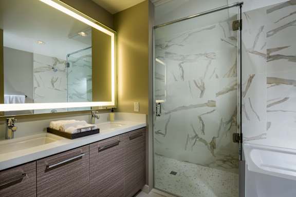 A bathroom with a marble patterned shower door.at Chelsea Santa Monica, Santa Monica, CA 90411