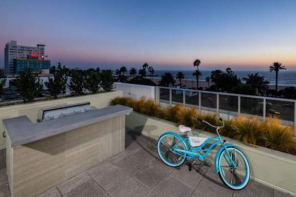 A blue bicycle is parked on a patio overlooking the ocean.at Chelsea Santa Monica, Santa Monica, 90411