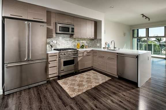 A modern kitchen with a refrigerator, oven, and microwave.at Chelsea Santa Monica, Santa Monica