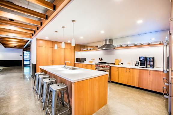 A modern kitchen with wooden cabinets and a large island.at The Rise, California
