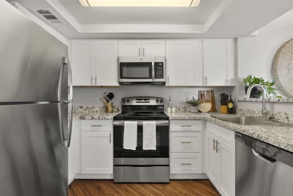 a kitchen with stainless steel appliances and white cabinets at Vaseo Apartments, Phoenix Arizona
