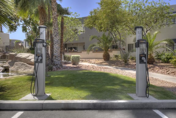 two gas pumps in a parking lot in front of a house at Vaseo Apartments, Phoenix, AZ
