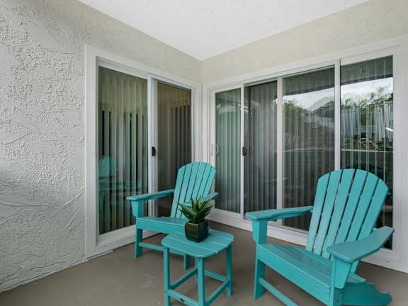 A turquoise chair and table are on a patio at Verandas Apartments, West Covina, 91791