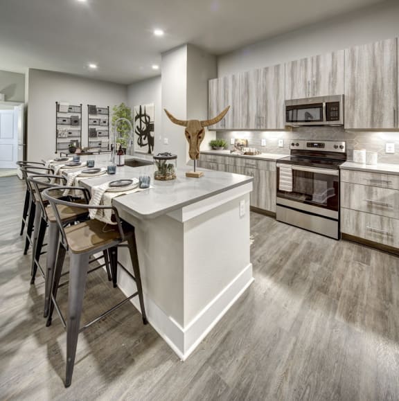 a kitchen with a large center island and a dining table at Arise Riverside, Texas, 78741